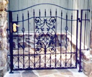 wrought iron walkway gate with grape pattern and brass deadbolt