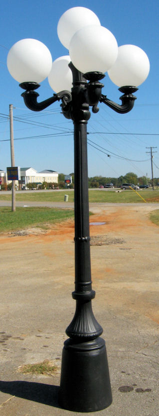 4 arm 5 light cast aluminum street lamp post with round globes and a black finish